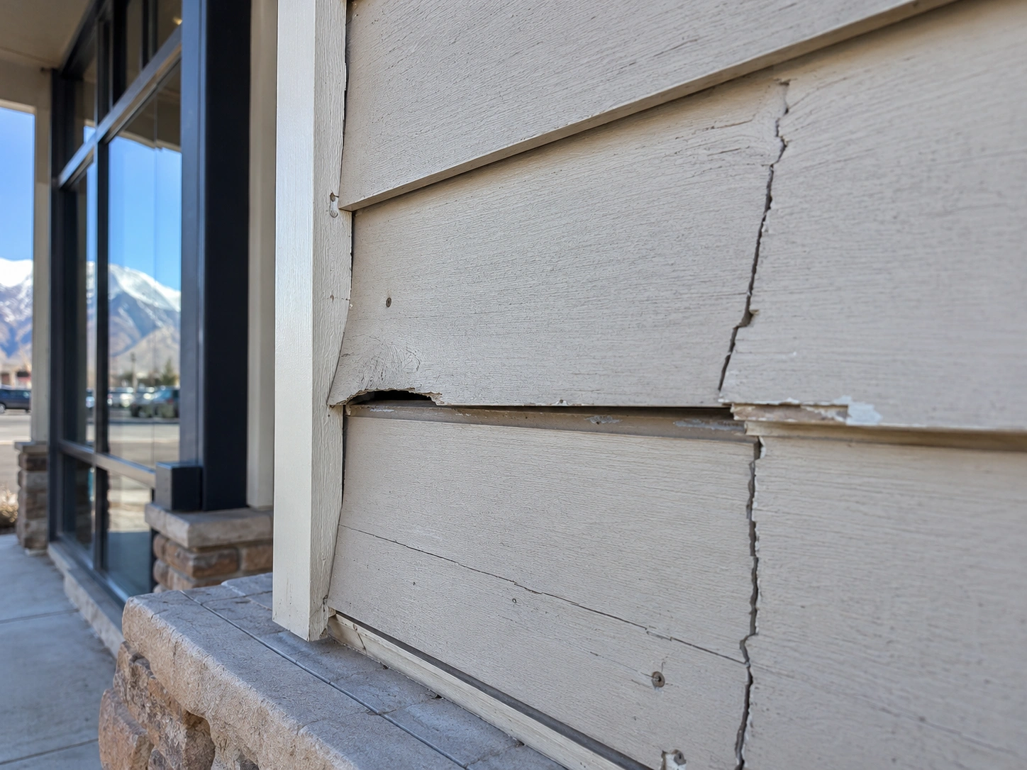 Damaged siding and distant mountains